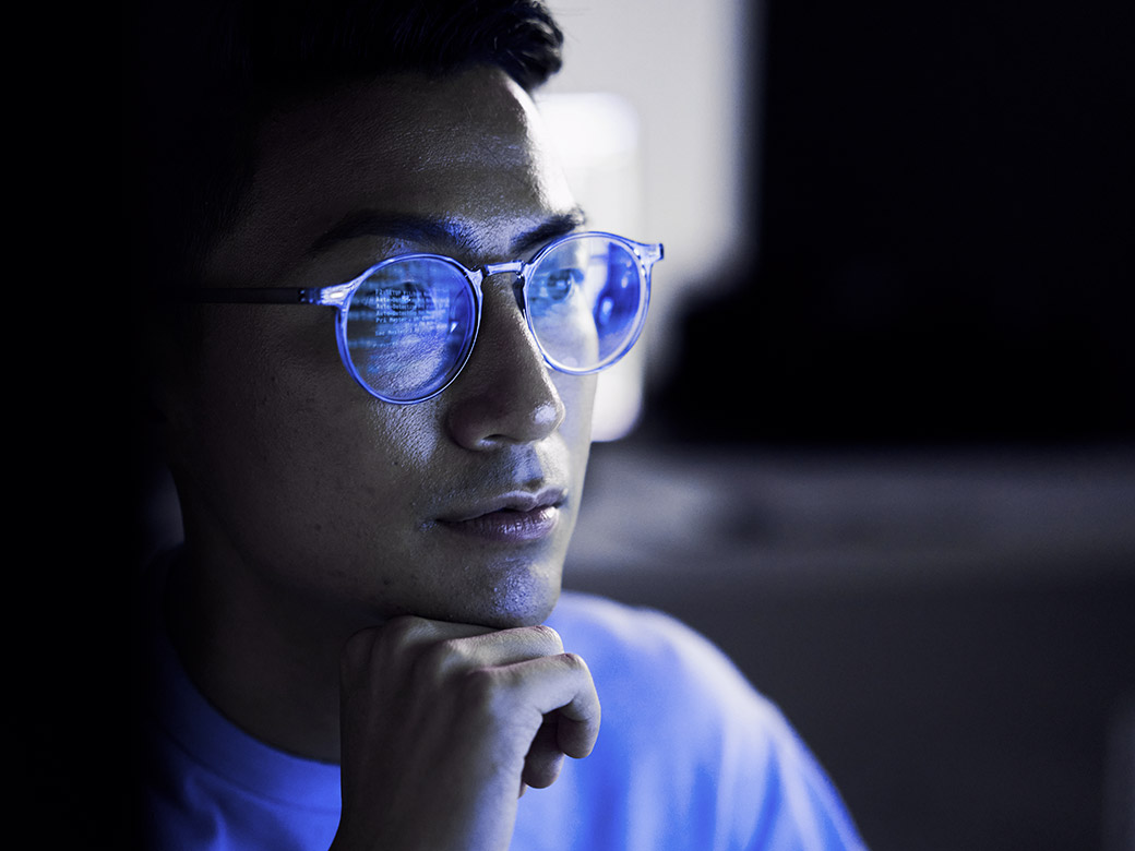 Person wearing glasses looking at code on screen